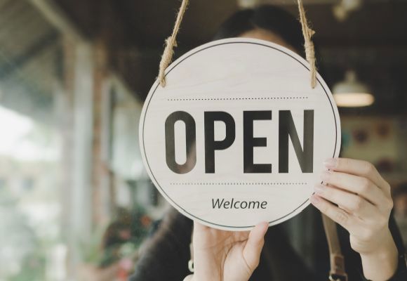 Panoramic banner. friendly waitress woman turning Open sign board